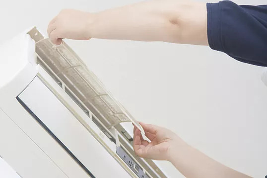 Engineer changing air conditioning filter